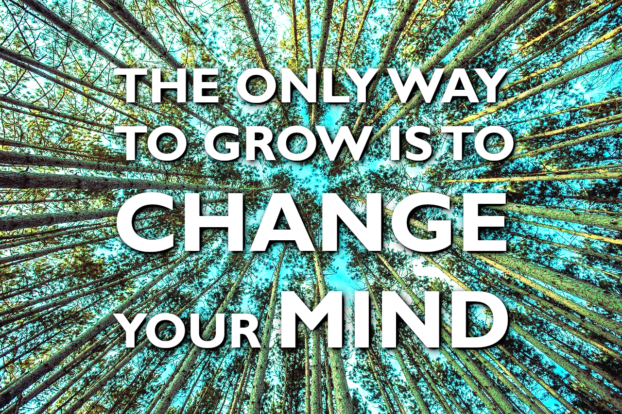 A background of trees with the words "the only way to grow is to change your mind" superimposed over it